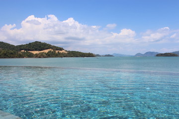 Fototapeta premium Widok na morze i wyspy górskie przez basen bez krawędzi w nadmorskim kurorcie w Langkawi w Malezji