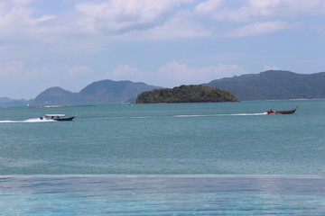 Obraz premium Boats and beautiful mountains near a beach resort in Langkawi, Malaysia
