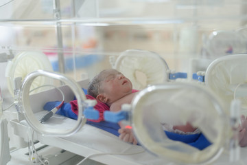 newborn baby inside incubator to receive medical treatment