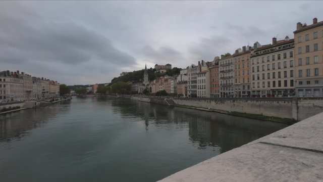 DOLLY SLOW Heading into Vieux Lyon over the Pont Bonaparte. Quai Tilsitt and Quai Fulchiron on the banks of the Saone river, Passerelle, Saint Georges church and Saint-Just College on Fourviere hill.