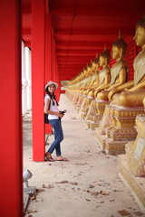 Fototapeta na wymiar Woman standing at the line of Buddha statue in Wat Tha Sung, Uthai Thani, Thailand.