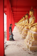 Fototapeta premium Man standing at the line of Buddha statue in Wat Tha Sung, Uthai Thani, Thailand.