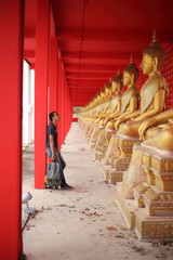 Fototapeta premium Man standing at the line of Buddha statue in Wat Tha Sung, Uthai Thani, Thailand.