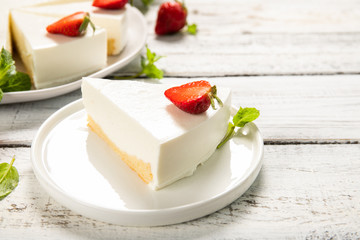 Plate with delicious strawberry cheesecake on a wooden background. Close-up.