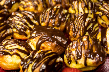 tray of delicious golden homemade profiteroles filled with cream and coated in chocolate. Best top desserts