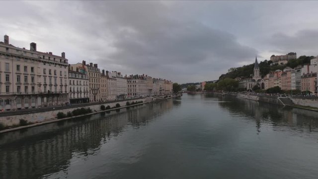 SLOW MOTION SHOT - Heading into Vieux Lyon over the Pont Bonaparte. Quai Fulchiron on the banks of the Saone river, Passerelle ,Saint Georges church and Saint-Just College on Fourviere hill.