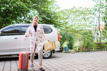 muslim woman coming back home on eid mubarak meeting her family