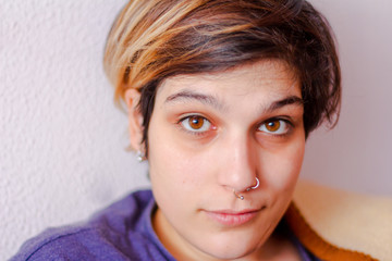 Girl with brown eyes and piercings looking to the camera