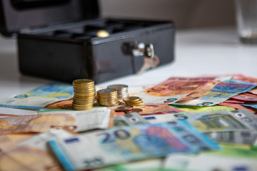 Bargeld auf dem Tisch vor einer Geldkassette