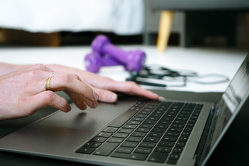 Close up hands typing on laptop home workout