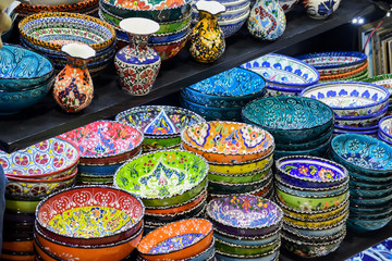 Fototapeta na wymiar Collection of turkish ceramics on sale at the Grand Bazaar in Istanbul, Turkey. Turkish colorful ornamental ceramic souvenir plates