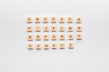 Spanish alphabet composed of letters on plastic pieces on a dark background.