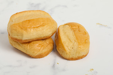 Fototapeta premium Breakfast buns on white marble background. Sweet brioche