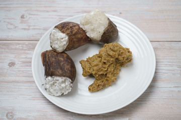 Glutinous rice steamed cooked with coconut milk in pitcher plants known as lemang periuk kera with spicy chicken rendang. A traditional malay cuisine during Hari Raya festival.