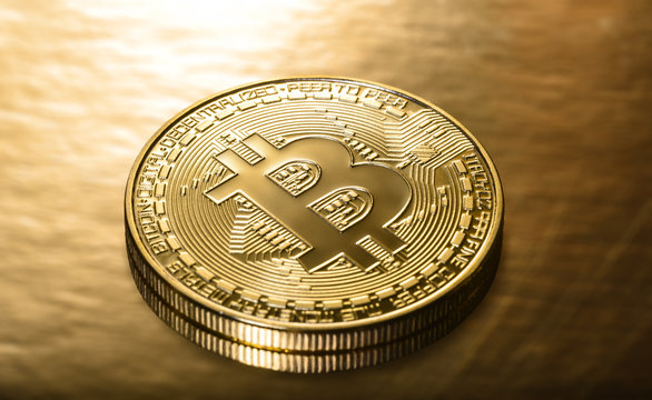 Crypto currency Golden Bitcoins on a gold background. Photo virtual money.Blockchain technology, bitcoin mining concept.