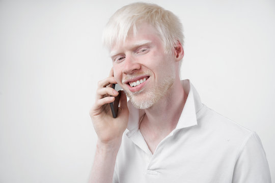 portrait of an albino man in studio dressed t-shirt isolated on a white background. abnormal deviations. unusual appearance