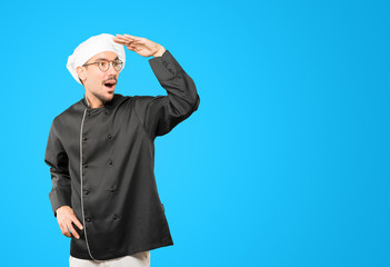Astonished young chef with a gesture of looking away