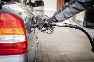 Gas station attendant pouring gasoline. Oil industry concept.