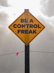 Caution sign: be a control freak (close up)