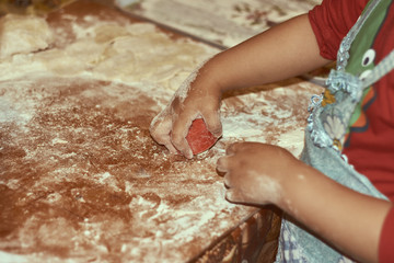 Cooking together with children. Little girl leaning how to make manti (Central Asia dumplings).
