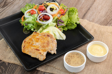 Fototapeta na wymiar Grilled chicken breast salad with dressings and orange juice on sackcloth wooden table - Copy space