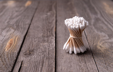 Bamboo cotton buds on wooden background. Muted tones healthy wellness cosmetics product