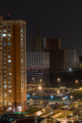 Obraz premium Butovo Park, Leninsky district of Moscow region, Russia-2020 . An area with numerous residential buildings. Suburbs. Suburban town in lights. Multicolored light in the Windows. Evening in the city.