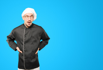 Amazed young chef looking up gesture