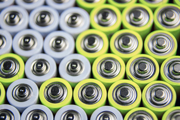 A large number of old AA batteries. The batteries are laid out in a square shape. Batteries form a...