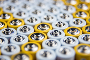 A large number of old AA batteries. The batteries are laid out in a square shape. Batteries form a...
