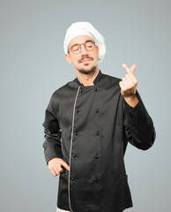 Young chef making a gesture of worried about his economy