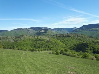 Mountain landscape with green grass and blue sky