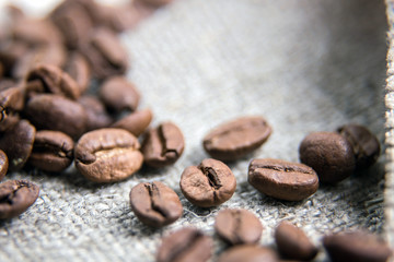 Brown coffee bean close-up.The grains lie on a sacking with a beautiful texture. Macrophotography of coffee. Beautiful grains.