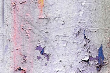 Close up view on colorful peeling paint with pink smudges