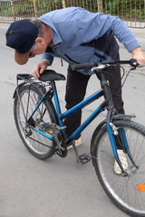 Fototapeta na wymiar man straightens a chain on a bicycle 