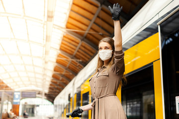 Fototapeta na wymiar Woman wearing white protective face mask is using public transportation during the epidemic outbreak