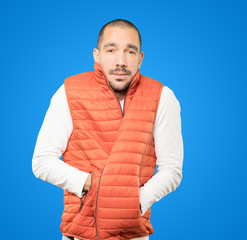 Concerned young man making a gesture of being cold