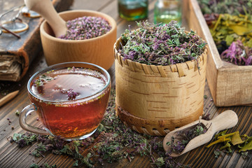 Cup of tea with wild Marjoram and Erica flowers. Dry Origanum vulgare and heather medicinal plants,...