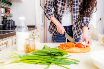 Step-by-step instructions on how to cook a vegetable salad with cabbage, tomatoes, green onions, spices and olive oil. Step 1. Cut the tomatoes.