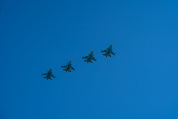 Fototapeta na wymiar Four aircrafts of russian air forces are flying in a row on bright blue sky