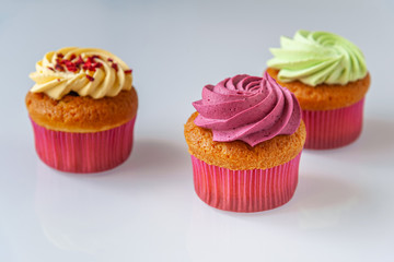 different cupcakes on a light glass surface close up