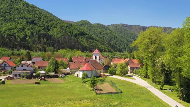 Croatia, town of Brod na Kupi in Gorski kotar on Kupa river, mountain landscape, panoramic view of town center from drone in spring, reveal footgae