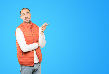 Hesitant young man pointing at you with his finger