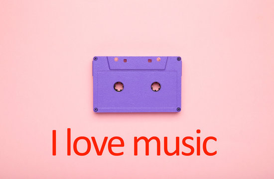 Inscription I love music with old colorful cassette on a pink background. Music day