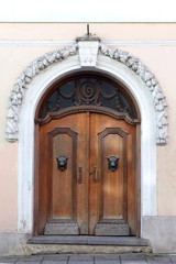 big wooden brown antique gates or doors. Wooden door with decoration elements in old building facade. Tallinn, Estonia