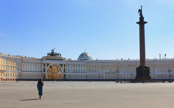 Lone woman on Palace Square in Saint Petersburg, Russia. Single unrecognisable female walking alone on empty Palace Square, main city square of St Petersburg