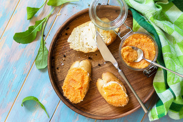 Snack or breakfast. Sandwiches with butter and salted caviar on a wooden kitchen table. Top view flat lay background.