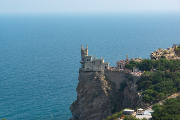 Fototapeta na wymiar Yalta - July 29, 2016: Monument of architecture and history in the village of Gaspra - Swallow's Nest. Sea horizon, Aurorina rock
