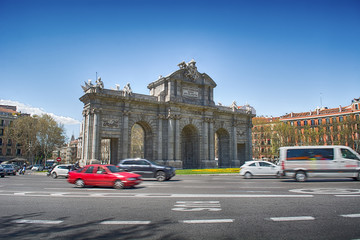 Fototapeta na wymiar Puerta de Alcalá in summer with blurred cars.