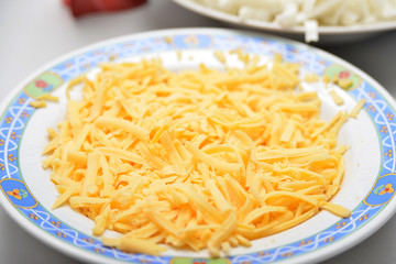 A lot of yellow cheese lies in a plate with flowers.